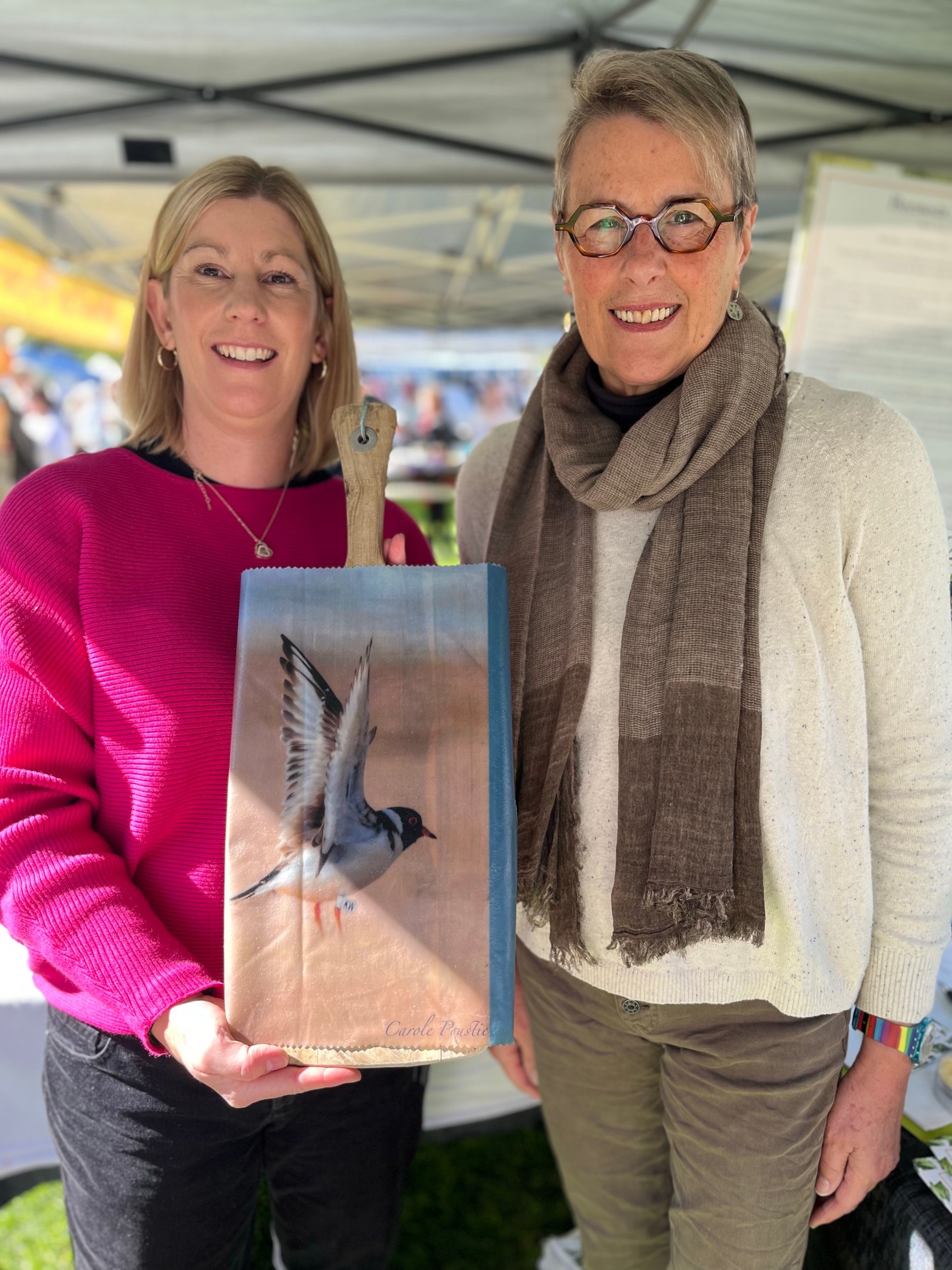 Kassandra from Bellarine Bee Wraps pictured with photographer Carole Poustie holding a Hooded Plover photographic beeswax wrap